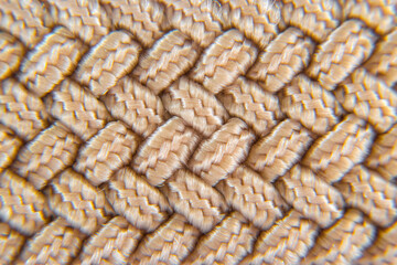 Close-up brown belt handmade braided woolen yarns texture background, center selective focus 