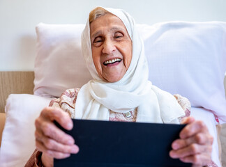 Portrait of senior Arabic woman using electronic tablet at home