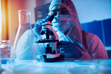 Doctor in the laboratory analyzes samples under a microscope. Pharmaceutical treatment concept.