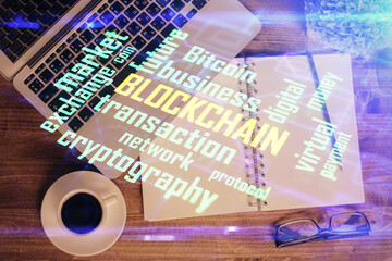 Blockchain theme hologram drawings over computer on the desktop background. Top view. Double exposure.