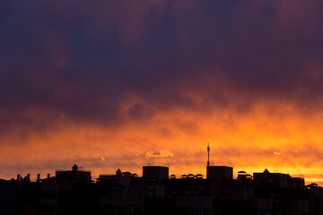 Fototapeta na wymiar Pink orange purple sunset over the city. Multicolored sky and black silhouette tall buildings of the metropolis