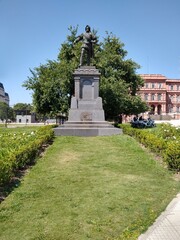 Christopher Columbus monument with a tree in the background in a square.