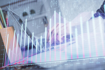 Double exposure of woman hands typing on computer and forex chart hologram drawing. Stock market...