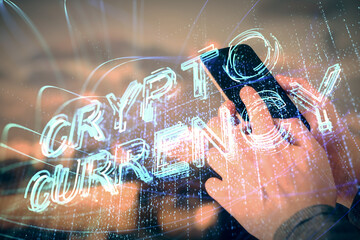 Double exposure of man's hands holding and using a phone and crypto currency blockchain theme...
