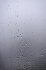 Raindrops on fogged window, rain falling, texture background, emotional sad
