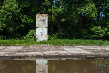 Abandoned pedestal without a monument on a background of greenery