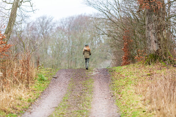 Girl walks in the woods on a rainy winter day