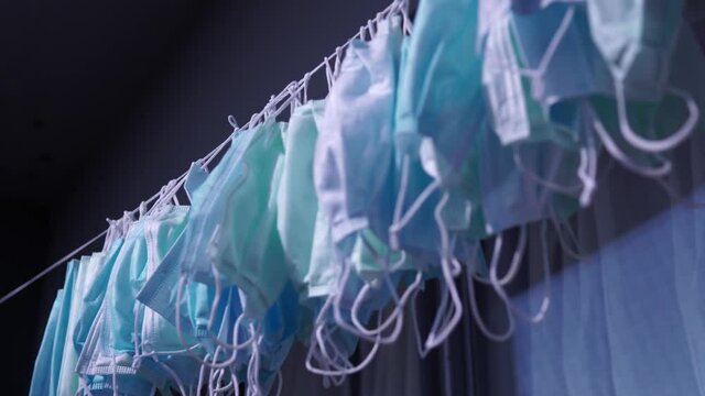 Hanging disposable masks hanging outside after washing for disinfection and sterilization. Concept of new normal, mandatory face masks bylaw in public indoor settings. Reuse, shortage and price gougin