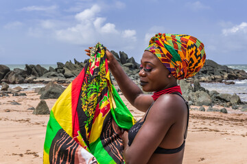 Ghana woman on the beautiful beach of Axim, located in Ghana West Africa. Headdress in traditional...