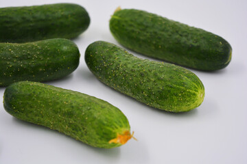 Young juicy cucumbers, Ukrainian cucumber harvest arranged on a white background. Fresh vegetables, healthy food for every day.