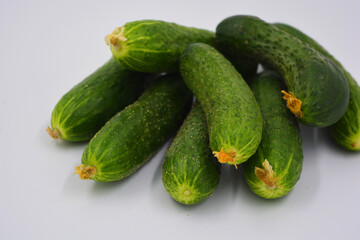 Young juicy cucumbers, Ukrainian cucumber harvest arranged on a white background. Fresh vegetables, healthy food for every day.