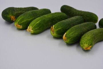 Young juicy cucumbers, Ukrainian cucumber harvest arranged on a white background. Fresh vegetables, healthy food for every day.