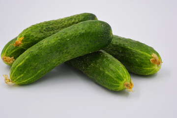 Young juicy cucumbers, Ukrainian cucumber harvest arranged on a white background. Fresh vegetables, healthy food for every day.