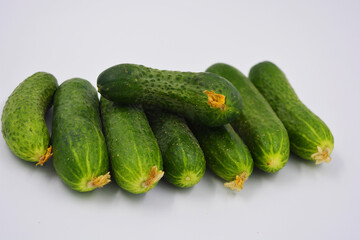 Young juicy cucumbers, Ukrainian cucumber harvest arranged on a white background. Fresh vegetables, healthy food for every day.