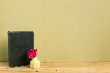 Vintage diary with flower on wooden table with khaki background. copy space