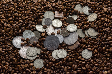 Soviet Union coins fall on coffee beans. Two dollars in silver. Charms and bark of the Mamvri oak. Washingtonia Leaflet. Flatley. Souvenirs on a dark background. Brown background.