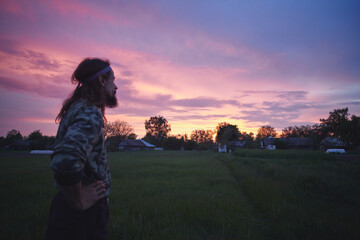 Young Caucasian rural man in his backyard at sunset.