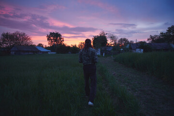 Young Caucasian rural man in his backyard at sunset.