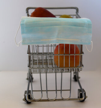 Miniature Shopping Cart With Full Size Apples And Protective Mask In Front