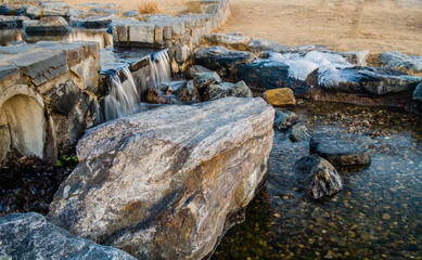 Man made waterfall emptying into a rocky stream
