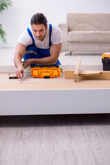 Young male contractor installing furniture at home