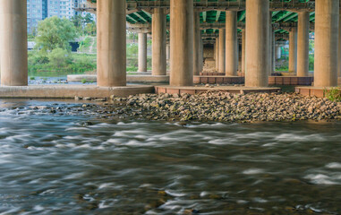 River flowing rapidly under bridge