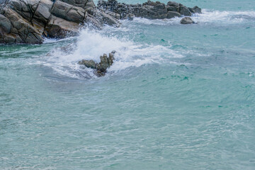 Ocean waves crashing against large boulders