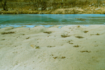 Sandy beach of frozen river