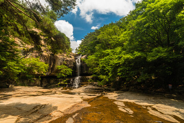 Waterfall cascading down rocky mountainside.