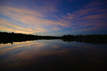 Fototapeta premium Brilliant colorful clouds in twilight reflected on calm water of Eco Pond in Everglades National Park, Florida on summer evening.