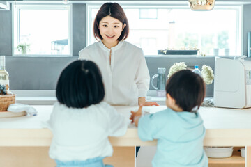 Obraz premium リビングで子供たちの姿を笑顔で見ている母親 kids mother