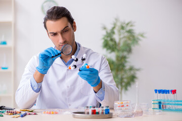 Young male lab assistant in drug synthesis concept