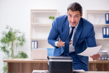 Young male employee making copies at copying machine