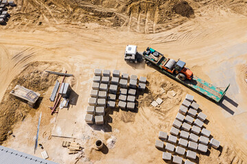 truck with long trailer platform for transporting heavy machinery, loaded road roller. aerial top view of construction site