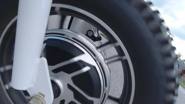 Riding electric bicycle on the city streets. Camera view to the power motor or electro motor of the wheel. Natural lighting. Close up.