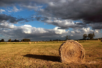 Dark clouds over a sheaf of hay in the meadow.