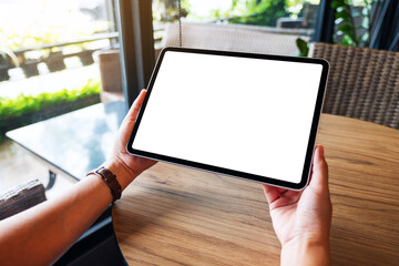 Mockup image of a woman holding black tablet pc with blank white desktop screen