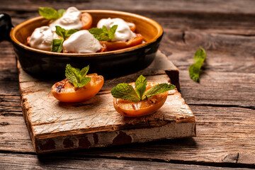 Grilled peaches and mascarpone with mint leaves on a wooden background, catering, banner menu recipe place for text