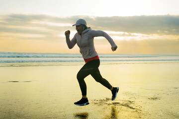 Silhouette of middle aged woman running on the beach - 40s or 50s attractive mature lady doing...