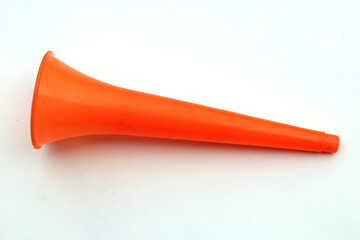 a orange color plastic vuvuzela horn isolated on white background
