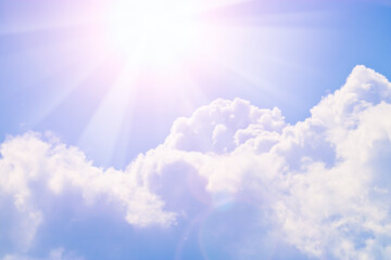 Cumulus clouds in the blue sky and sunbeams break through the clouds. Copy space