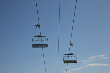 Ski lift strolling across blue sky