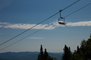 Ski lift strolling across blue sky