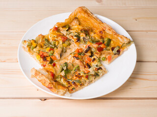 Homemade delicious pizza. The pieces are on a round white plate. Traditional cuisine