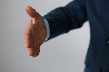 Man in suit and tie give hand as hello in office closeup. Friend welcome, mediation offer, positive introduction, thanks gesture, summit participate approval, motivation, male arm, strike bargain