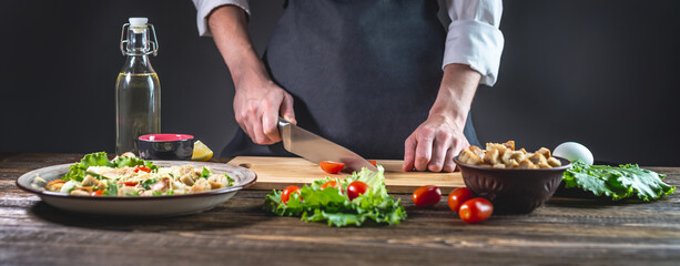 Chef is cutting the tomatoes. Concept of the process of preparing a fresh delicious salad