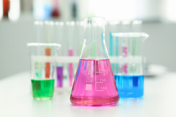 Chemical industry bulb with blue magenta pink liquid lab tubes stand on the table in the laboratory of liquid testing test development substances poisons additives stabilizers flavors house cleaning