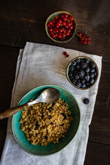 Breakfast food concept with cereals, yogurt and berries on concrete background with copy space
