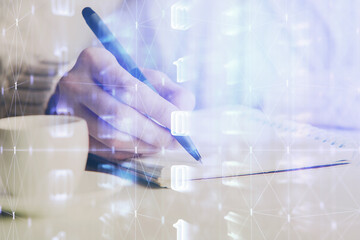 Double exposure of writing hands on background with data solution hologram on front. Technology concept. Close up