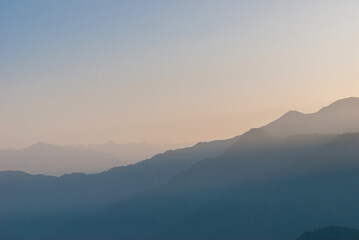 Obraz na płótnie Canvas The dark silhouettes of the mountains covered by the fog.